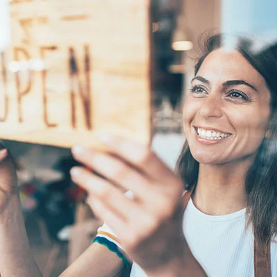 Women places open sign in window