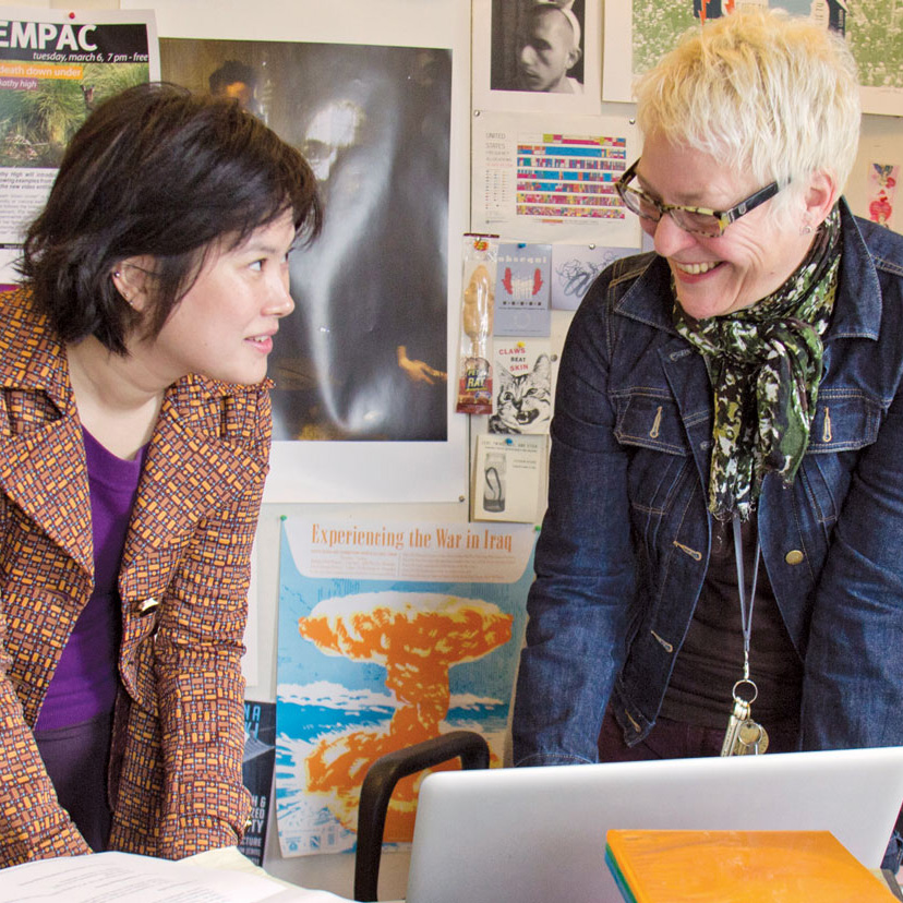 Two female professors in a discussion in front of a laptop