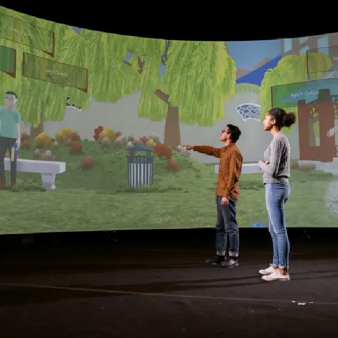 Two students view immersive environment screen