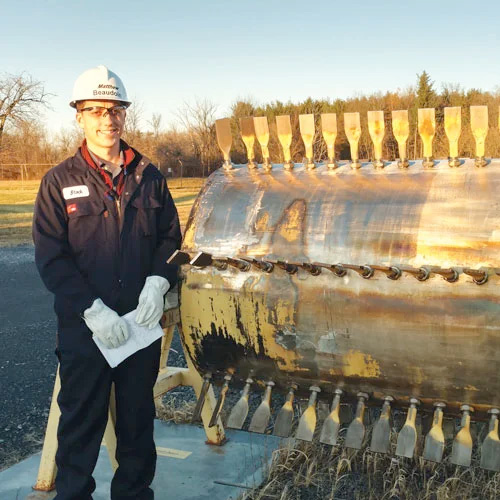 Student photo in front of equipment while on internship