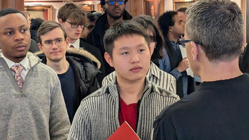 Group of students face forward listening to a speaker